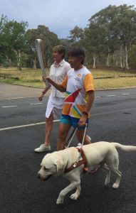 Comet guiding Lindy with Kerry in the Queen's Baton Relay
