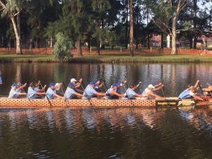 Dragon boat paddlers going past in the Forbes river with Lindy in the second row from the front